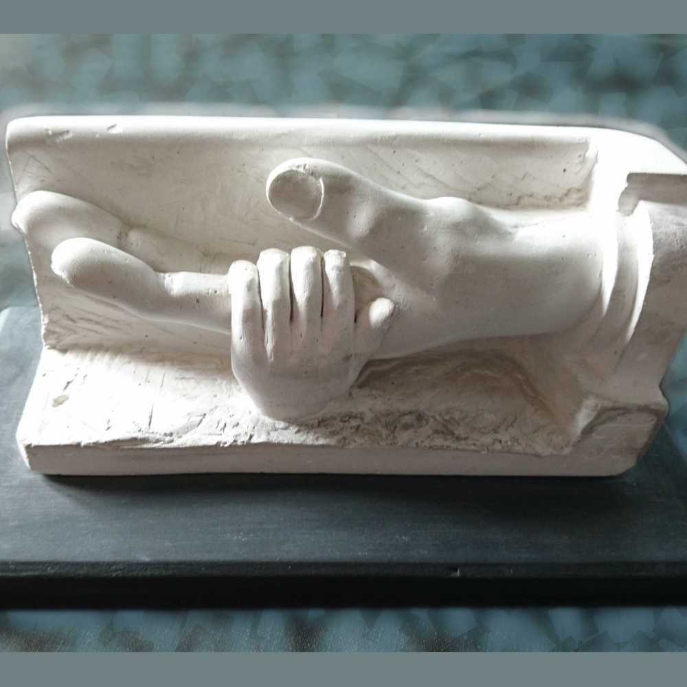 Main d'enfant tenant une main d'adulte en platre sculpté pour réaliser un moulage en bronze ou une contre épreuve